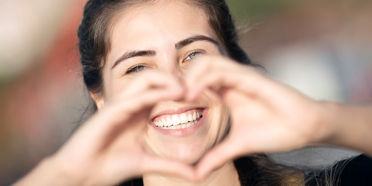 woman making heart shape with hands